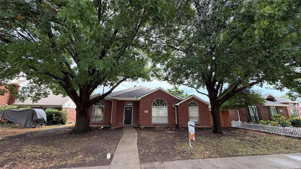 2718 High Pointe Boulevard, McKinney, TX 75071 Brick exterior with arched window details, a dark front door, and a concrete pathway