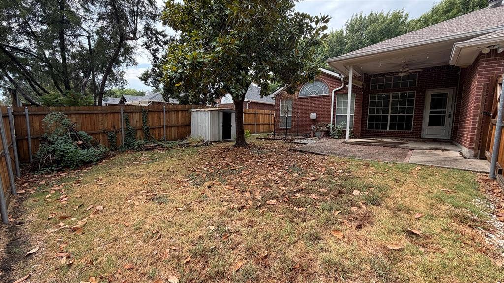 2718 High Pointe Boulevard, McKinney, TX 75071 Expansive backyard featuring a wood privacy fence, mature trees, and a covered patio