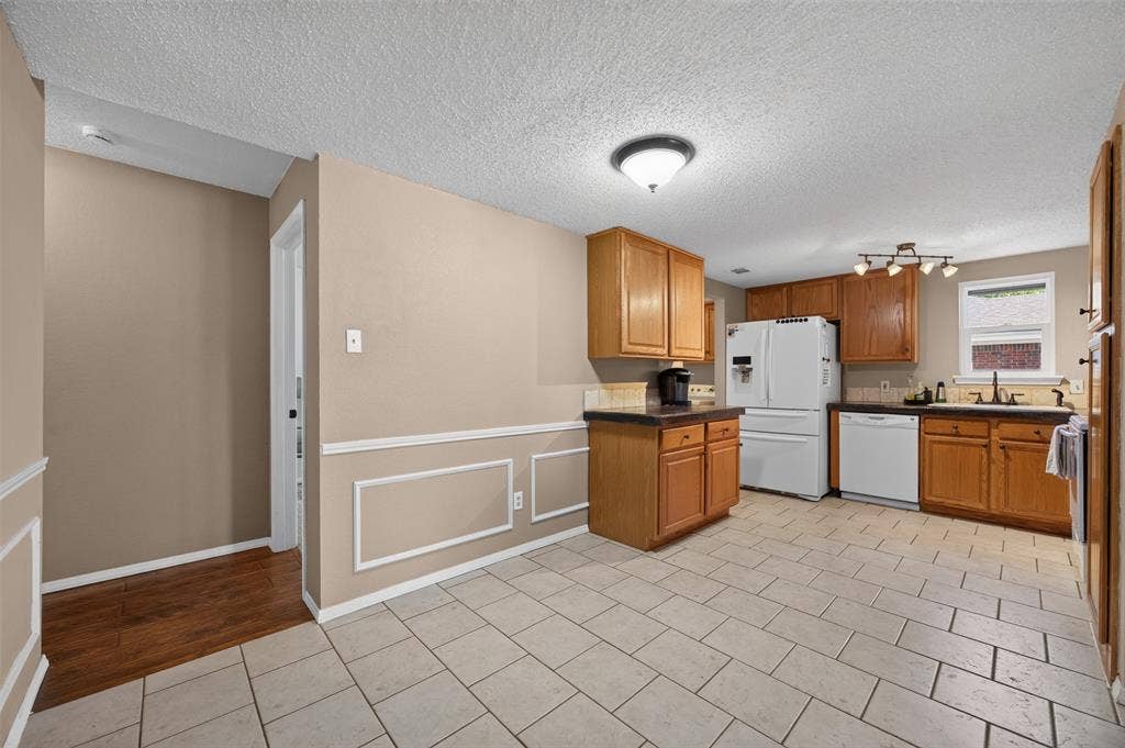 203 Briarglen Drive, Cedar Hill, TX 75104 Kitchen with light wood-finish cabinetry, white appliances, and a tile backsplash
