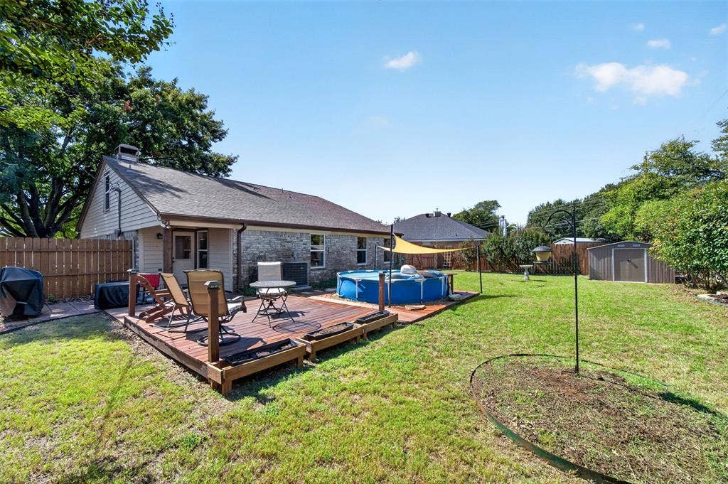 203 Briarglen Drive, Cedar Hill, TX 75104 Expansive backyard featuring a wood deck, brick and siding exterior, fenced perimeter, and a storage shed