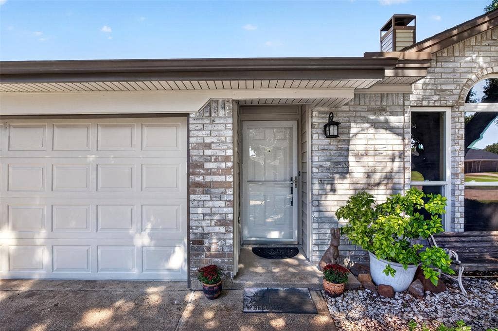 203 Briarglen Drive, Cedar Hill, TX 75104 Brick exterior with a paneled garage door and a covered entryway