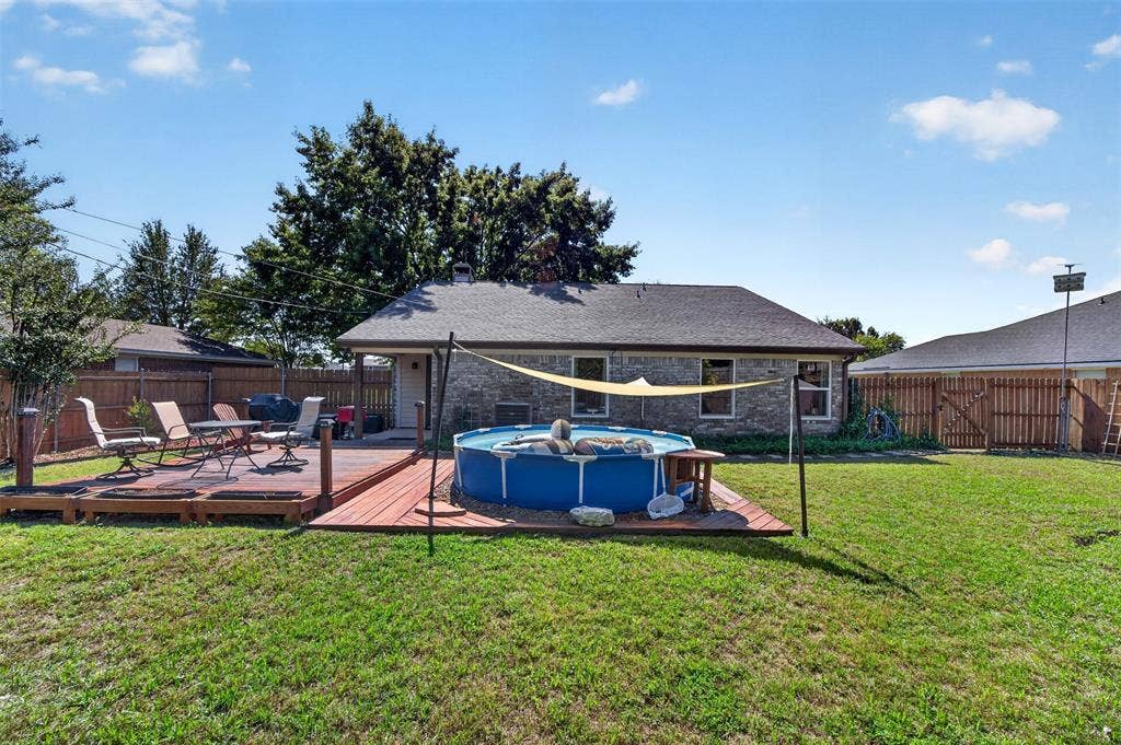 203 Briarglen Drive, Cedar Hill, TX 75104 Expansive backyard featuring a wood deck with a built-in pool, a brick exterior, and a privacy fence
