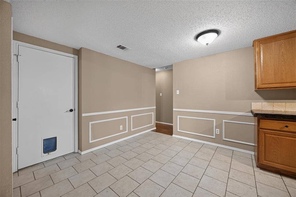 203 Briarglen Drive, Cedar Hill, TX 75104 Tile flooring, wainscoting, wood cabinetry, stone-look countertop, and a tiled backsplash