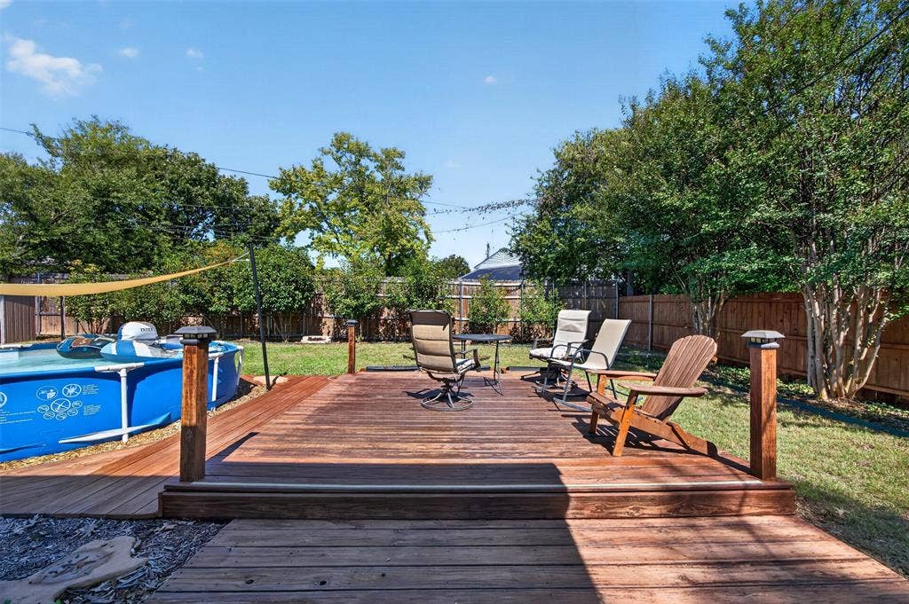 203 Briarglen Drive, Cedar Hill, TX 75104 Expansive backyard featuring a wood-finish deck with integrated lighting, a manicured lawn, and mature trees