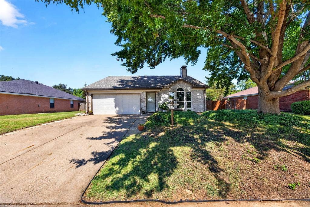 203 Briarglen Drive, Cedar Hill, TX 75104 Stone-clad exterior with a prominent arched window and a two-car garage