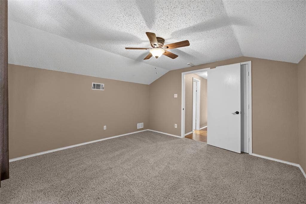 203 Briarglen Drive, Cedar Hill, TX 75104 Carpeted room with a ceiling fan, sloped ceilings, and a light-colored door