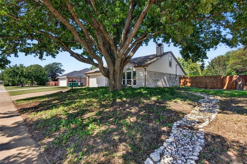 203 Briarglen Drive, Cedar Hill, TX 75104 Stone and siding exterior with an arched window, a prominent chimney, and a fenced perimeter