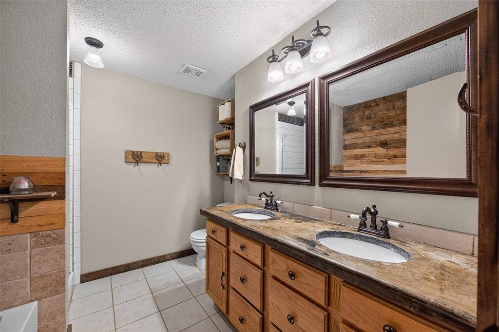 203 Briarglen Drive, Cedar Hill, TX 75104 Dual vanity with integrated sinks, wood-finish cabinetry, and framed mirrors