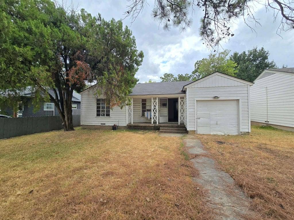 2710 Exeter Avenue, Dallas, TX 75216 White siding exterior with a covered porch entry, attached single-car garage, and a concrete walkway
