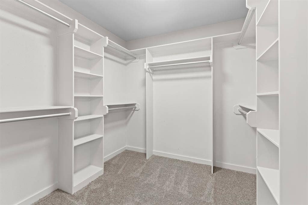 16514 Crossing Circle, Lindale, TX 75771 Built-in white shelving and hanging rods, recessed ceiling lighting, and gray carpet flooring