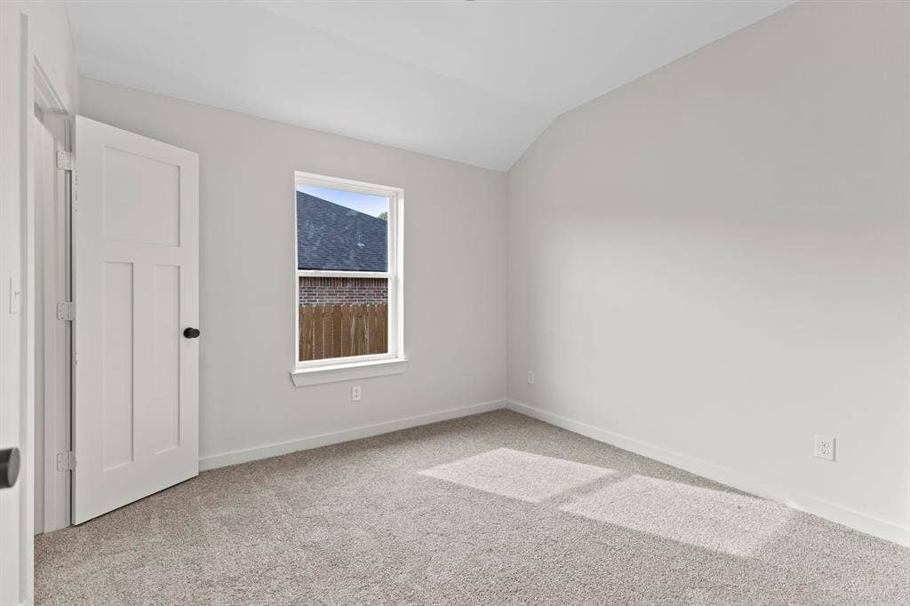 16514 Crossing Circle, Lindale, TX 75771 Neutral wall paint, plush carpeting, white trim, and a paneled door with a black doorknob