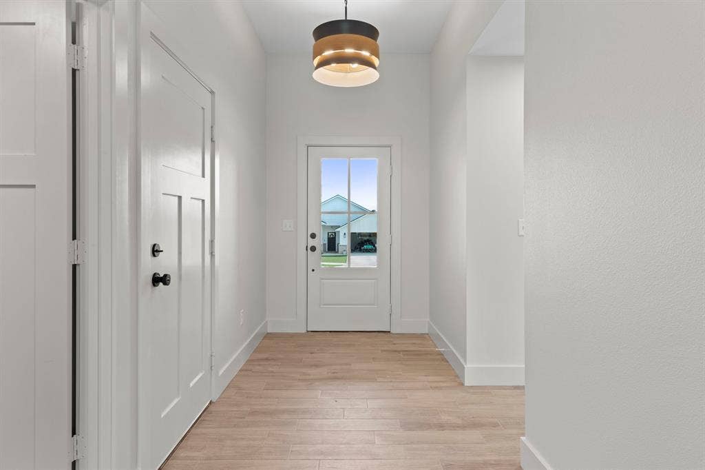 16514 Crossing Circle, Lindale, TX 75771 Light wood-finish flooring, white paneled doors, and a decorative semi-flush mount light fixture
