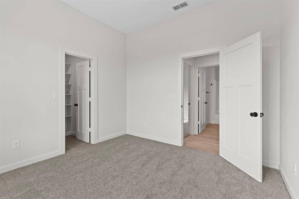 16514 Crossing Circle, Lindale, TX 75771 Grey carpet flooring, white walls, white trim, white interior doors with black hardware, and a built-in shelving unit