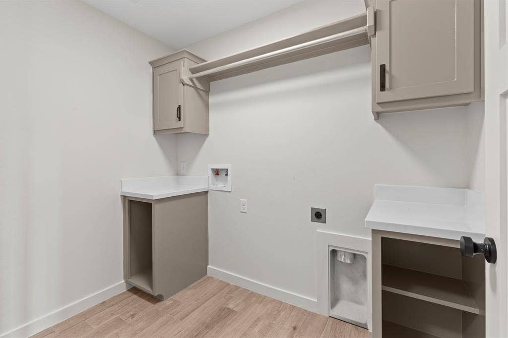 16514 Crossing Circle, Lindale, TX 75771 Laundry area featuring wood-finish flooring, built-in cabinetry, white countertops, and a clothing rod