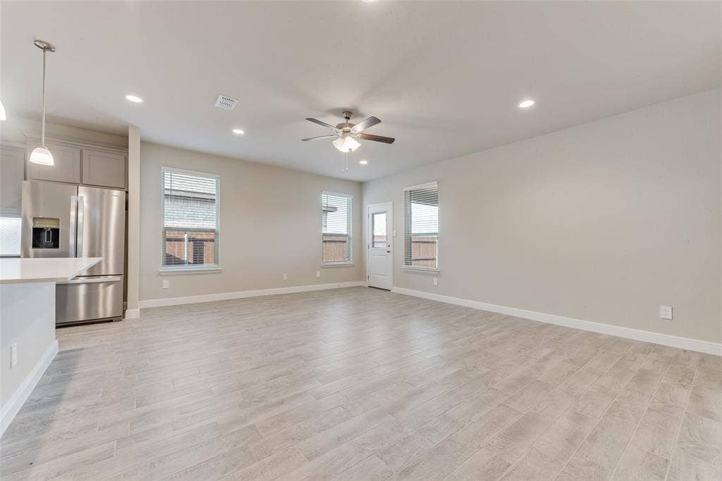 Unfurnished living room with ceiling fan and light hardwood / wood-style flooring
