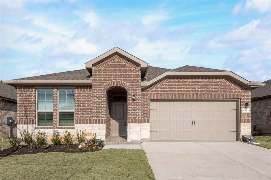 View of front of home with a garage and a front yard