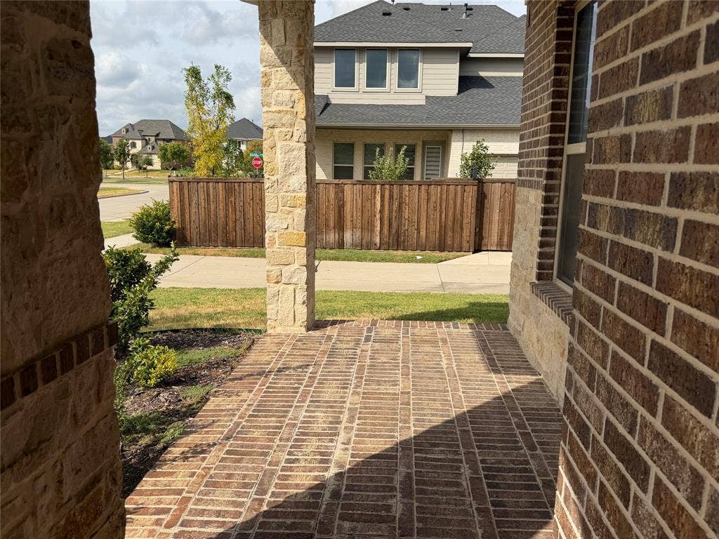 1196 Putnam Drive, Frisco, TX 75036 Brick and stone exterior with a covered front porch featuring a brick-patterned floor
