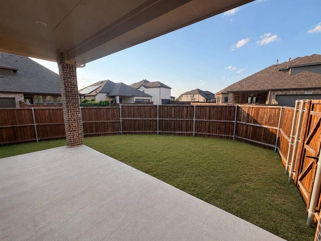 1196 Putnam Drive, Frisco, TX 75036 Covered patio with a brick column, concrete flooring, and an expansive lawn area