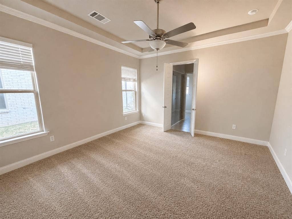 1196 Putnam Drive, Frisco, TX 75036 Private primary bedroom in back of the house with recessed ceiling with crown molding, ceiling fan, and light fixture and ensuite bath