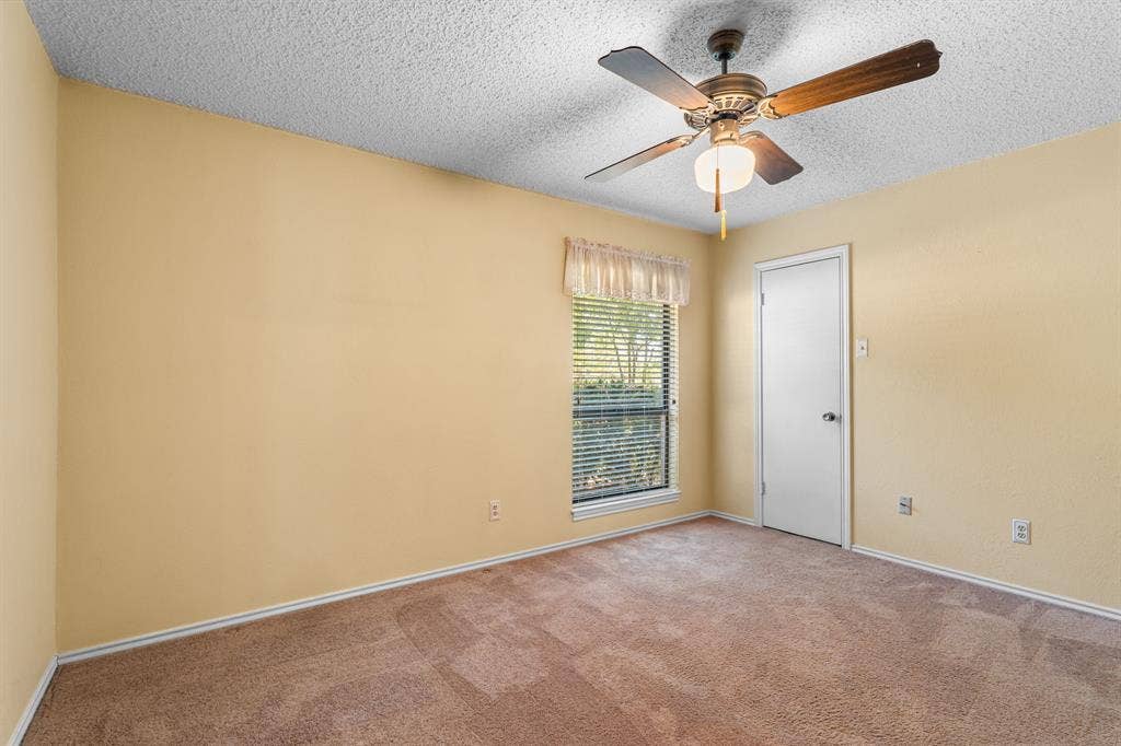 544 Jason Street, Robinson, TX 76706 Textured ceiling, ceiling fan with integrated lighting, carpeted flooring, window with blinds, and a white interior door