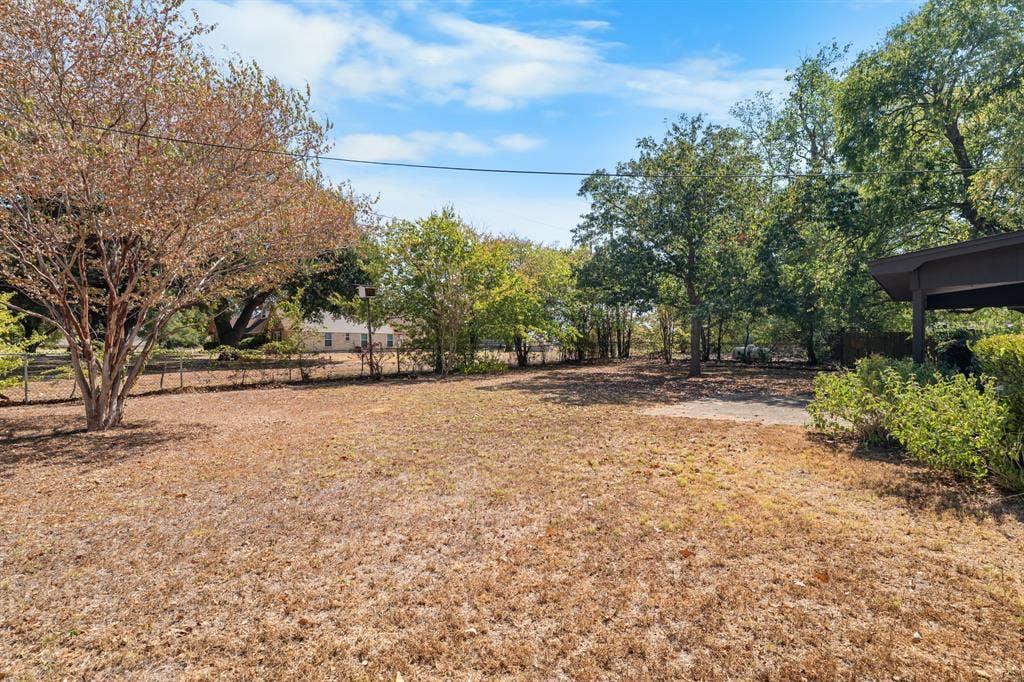544 Jason Street, Robinson, TX 76706 Expansive property featuring mature trees, a partially paved area, and a sloped roofline structure