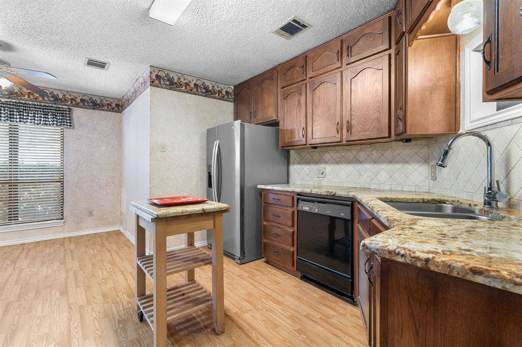544 Jason Street, Robinson, TX 76706 Kitchen featuring wood-finish flooring, wood cabinetry, stone countertops, stainless steel sink, and a ceiling fan