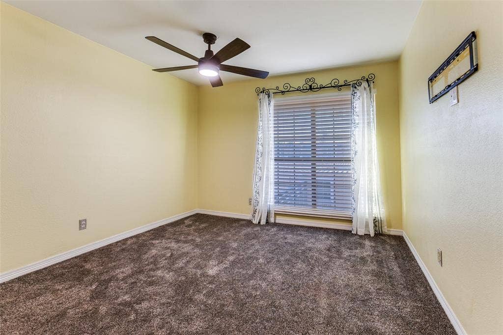 351 Valley Park Drive, Garland, TX 75043 351 Vally Park Dr. - Second-floor bedroom featuring newer carpet, a ceiling fan, and a window overlooking the backyard.
