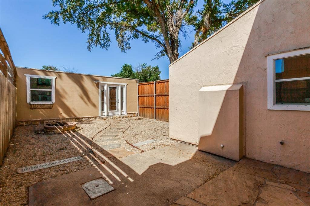 351 Valley Park Drive, Garland, TX 75043 351 Vally Park Dr. - Back of home featuring a low-maintenance backyard with a fire pit, perfect for relaxing or entertaining outdoors.