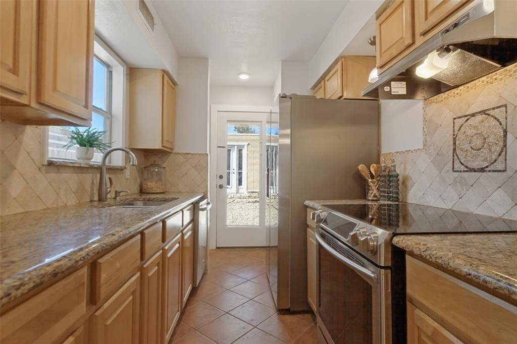 351 Valley Park Drive, Garland, TX 75043 351 Vally Park Dr. - Updated kitchen featuring Spanish tile flooring, granite countertops, beautiful mosaic tile backsplash and stainless steel appliances, including the refrigerator.