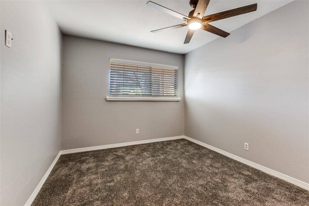 351 Valley Park Drive, Garland, TX 75043 351 Vally Park Dr. - Second-floor bedroom featuring newer carpet, a ceiling fan, and a window overlooking the backyard.