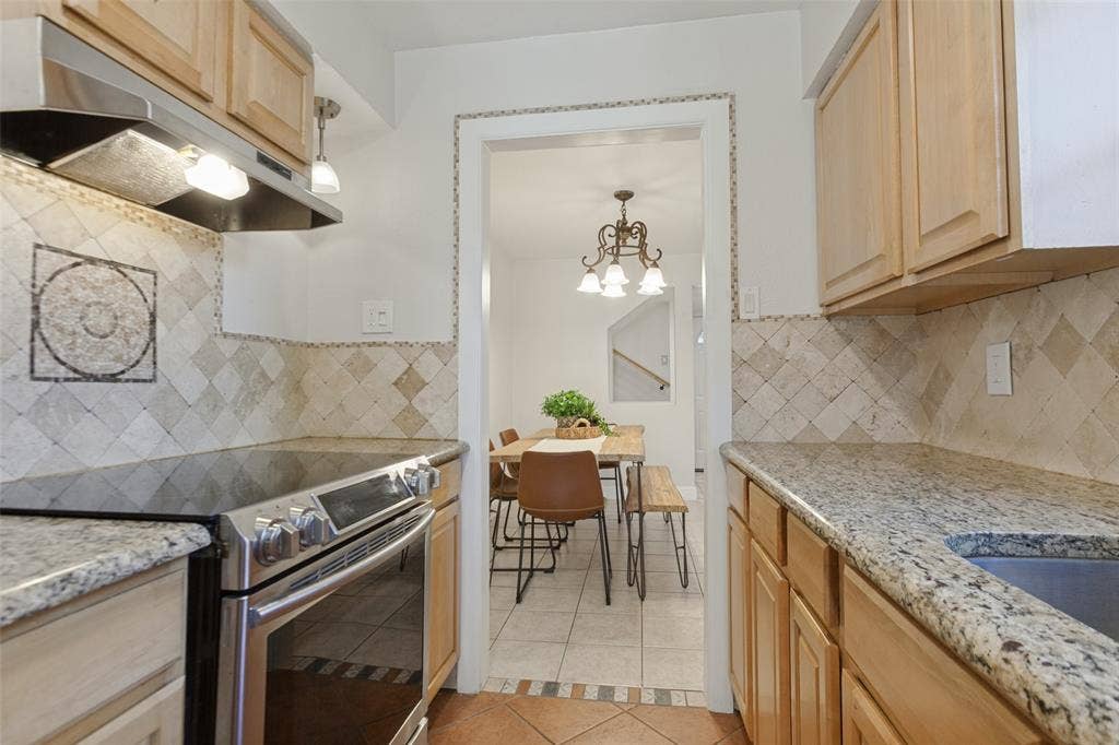 351 Valley Park Drive, Garland, TX 75043 351 Vally Park Dr. - Updated kitchen featuring Spanish tile flooring, granite countertops, beautiful mosaic tile backsplash and stainless steel appliances, including the refrigerator.