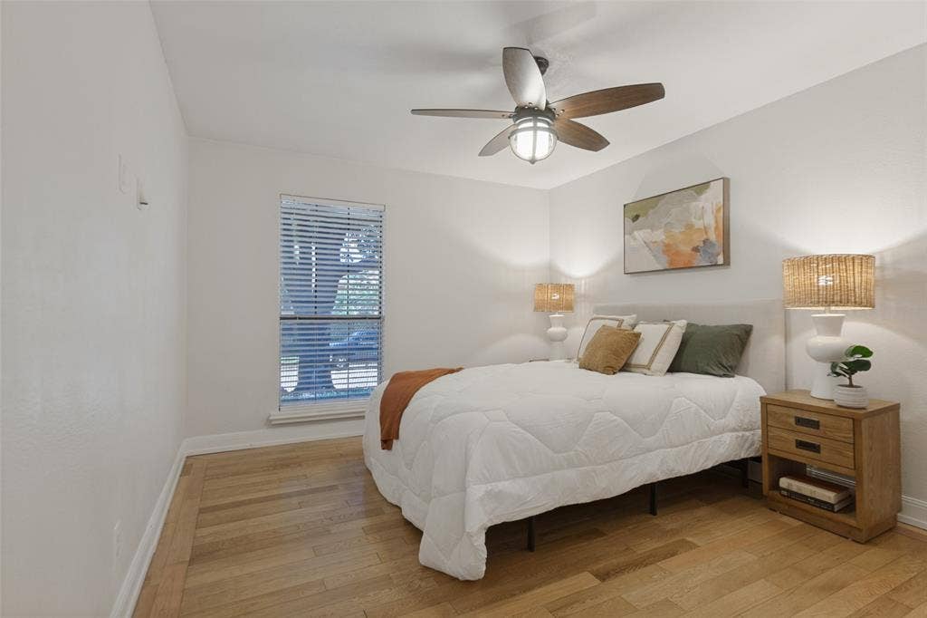 351 Valley Park Drive, Garland, TX 75043 351 Vally Park Dr. - Spacious primary bedroom featuring a ceiling fan and wood-look flooring, creating a comfortable and inviting retreat.