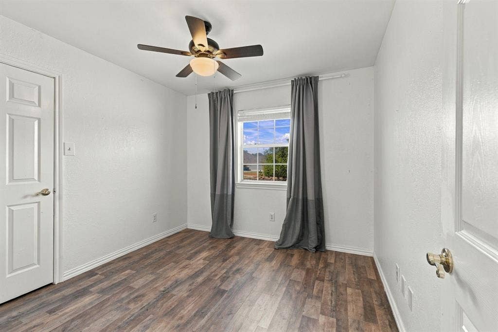 1015 Shelly Drive, Keene, TX 76031 Recessed window with gray drapes, wood-finish flooring, and a ceiling fan with integrated lighting