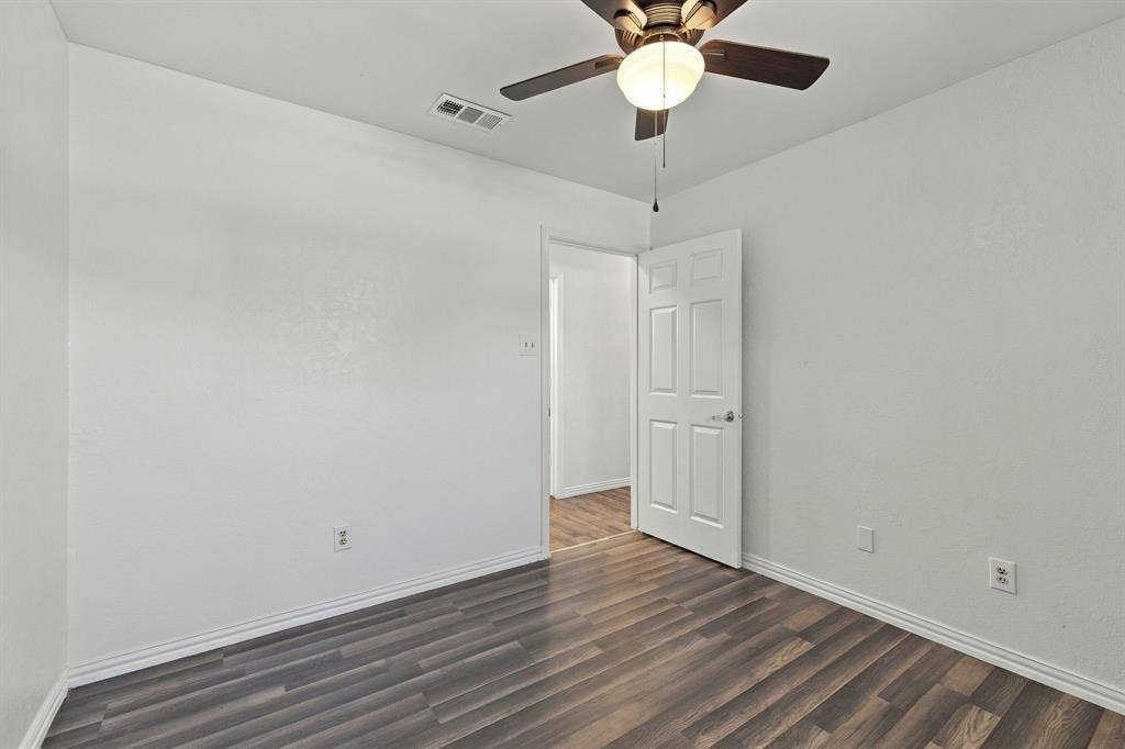 1015 Shelly Drive, Keene, TX 76031 Wood-finish flooring, white paneled door, and a ceiling fan with integrated lighting
