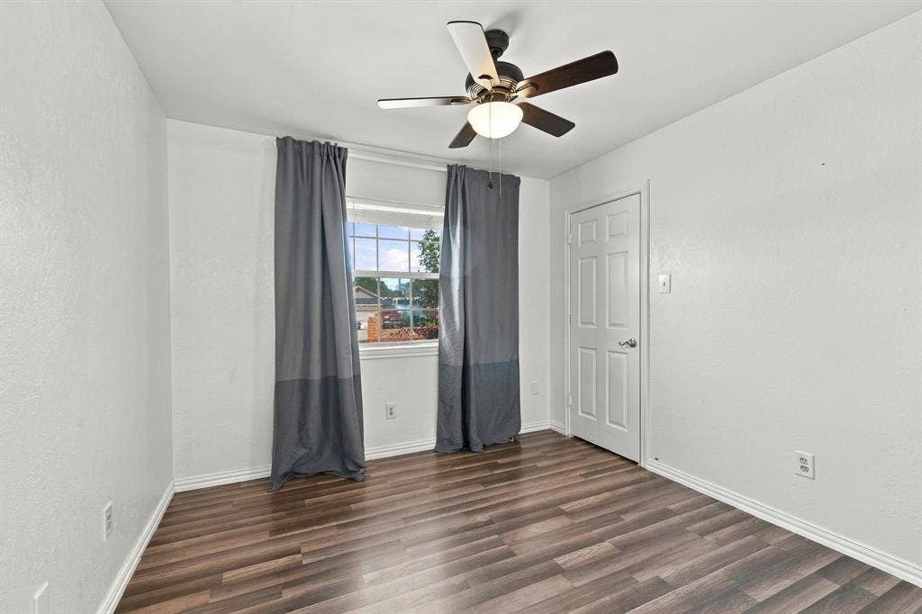 1015 Shelly Drive, Keene, TX 76031 Wood-finish flooring, white walls, ceiling fan with integrated lighting, and a white paneled door