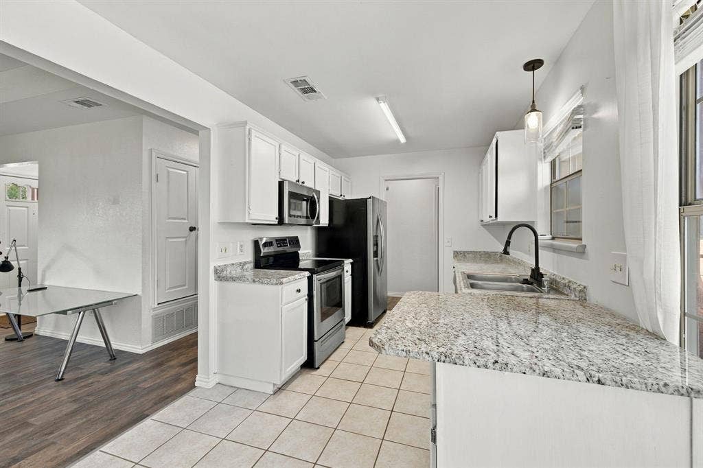 1015 Shelly Drive, Keene, TX 76031 Kitchen featuring white cabinetry, light-colored countertops, stainless steel appliances, and tile flooring