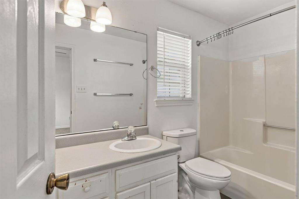 1015 Shelly Drive, Keene, TX 76031 White vanity with integrated sink, rectangular mirror, and an overhead light fixture