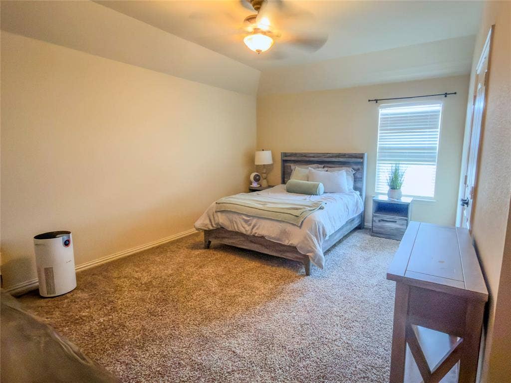Carpeted flooring, ceiling fan with integrated lighting, window with blinds, and painted walls