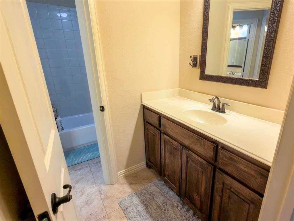 White vanity countertop with an integrated sink and a dark-toned cabinet