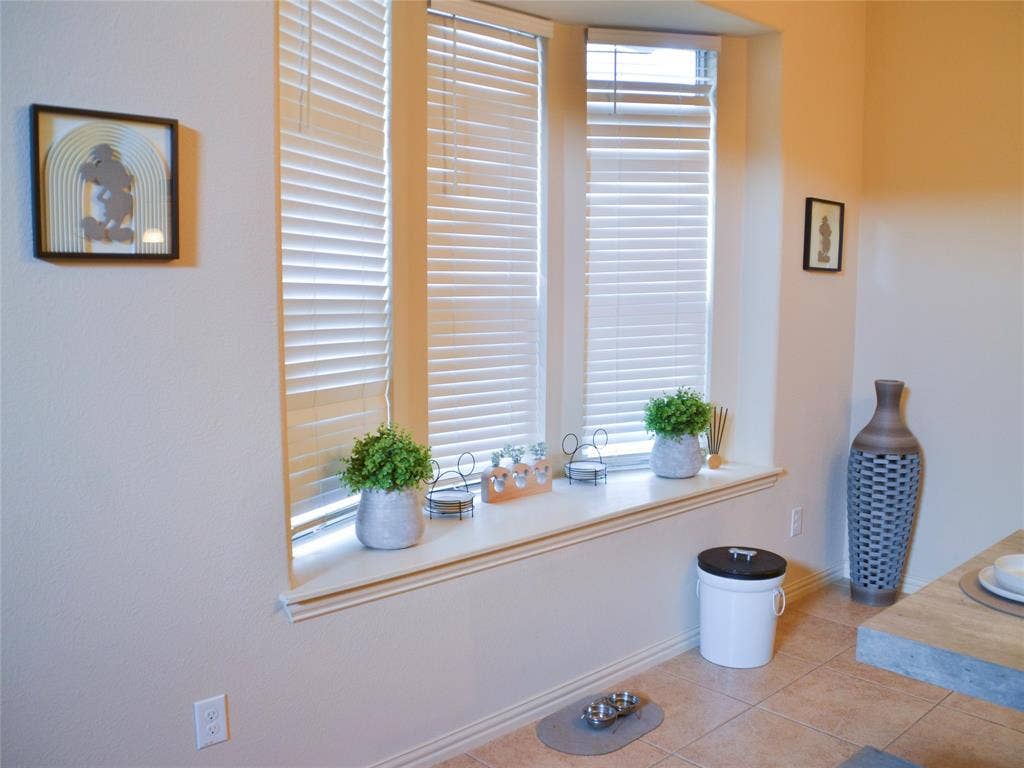 Bay window with window blinds, a built-in window seat, and neutral-toned walls