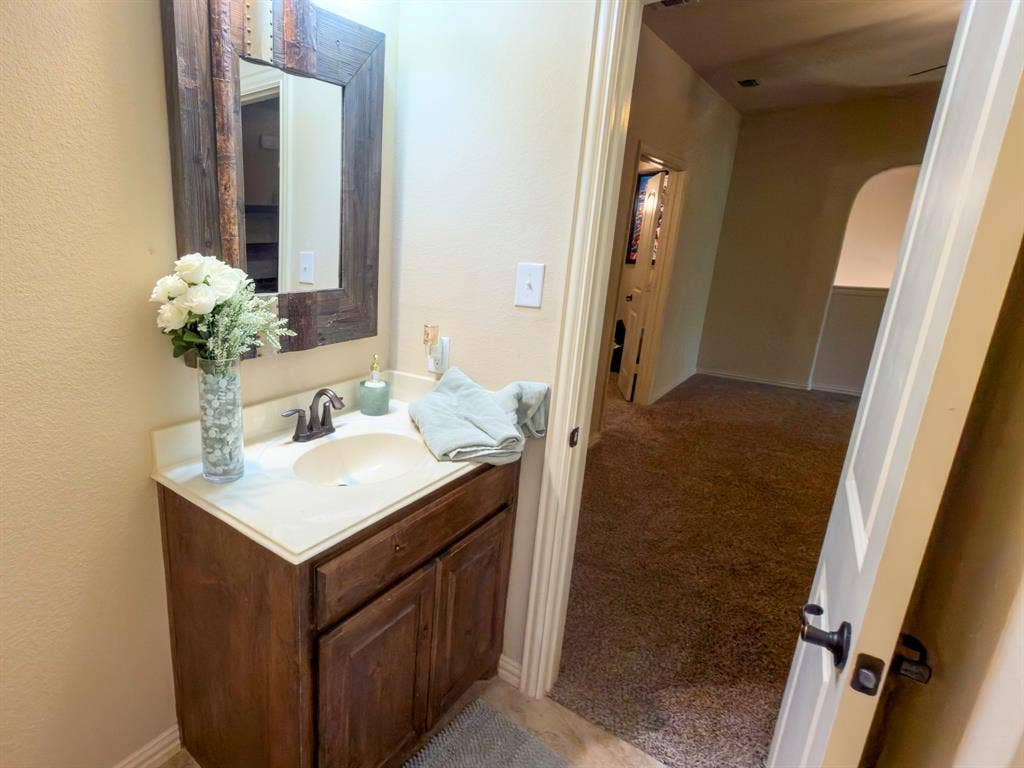 Vanity with a wood-finish cabinet, integrated sink, and bronze-finish faucet