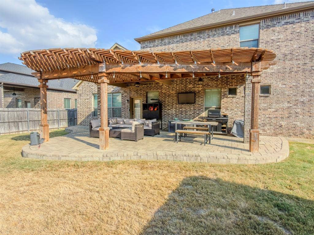 Extended paver patio with a wood pergola structure