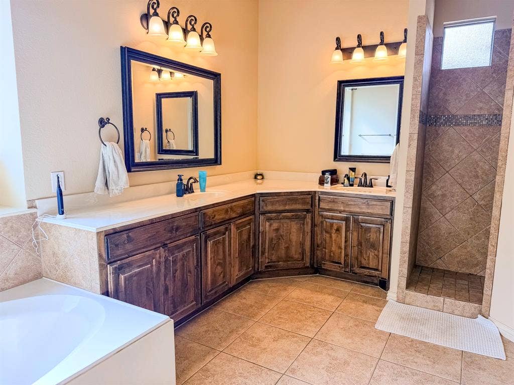 Dual vanities with wood-finish cabinetry and light-toned countertops