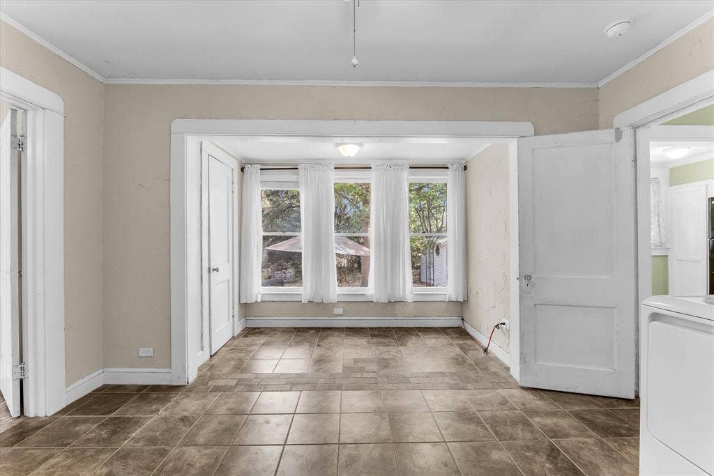 302 W Billington Drive, Robinson, TX 76706 Brown tile flooring, white trim, and three windows with white curtains
