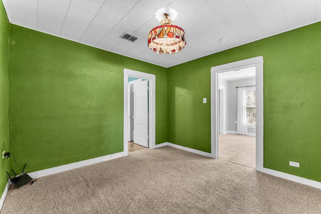302 W Billington Drive, Robinson, TX 76706 Textured green wall finish, white ceiling with paneling, stained glass chandelier, and neutral carpet flooring