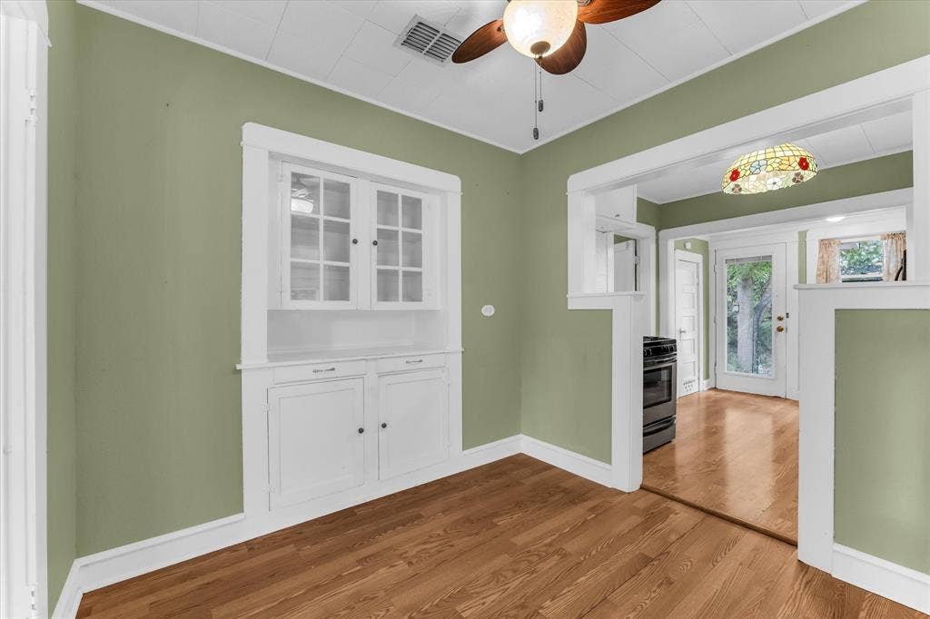 302 W Billington Drive, Robinson, TX 76706 Built-in cabinetry with glass-front uppers, wood-finish flooring, ceiling fan, and decorative light fixture