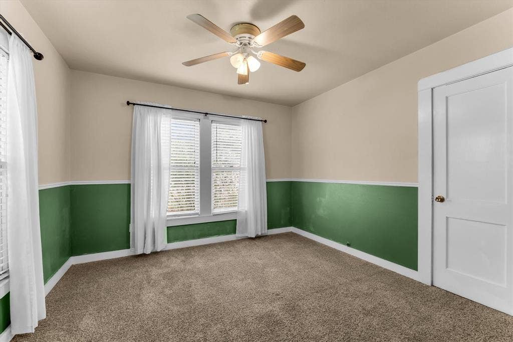 302 W Billington Drive, Robinson, TX 76706 Carpeted room featuring a ceiling fan with light fixture, dual windows with blinds, and two-tone wall treatment