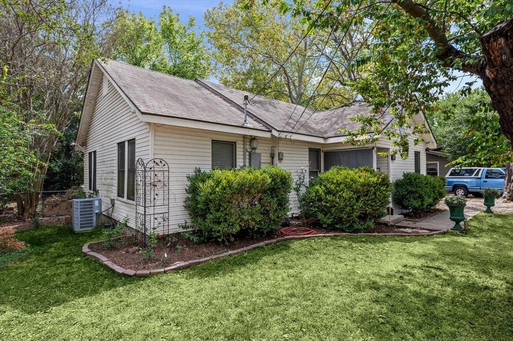 302 W Billington Drive, Robinson, TX 76706 Exterior featuring white siding, a sloped roof, and established landscaping with manicured shrubs