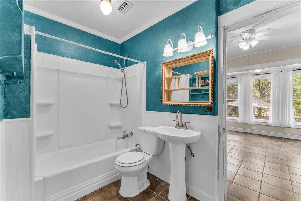 302 W Billington Drive, Robinson, TX 76706 Tub and shower combination with a pedestal sink, framed mirror, and tile flooring