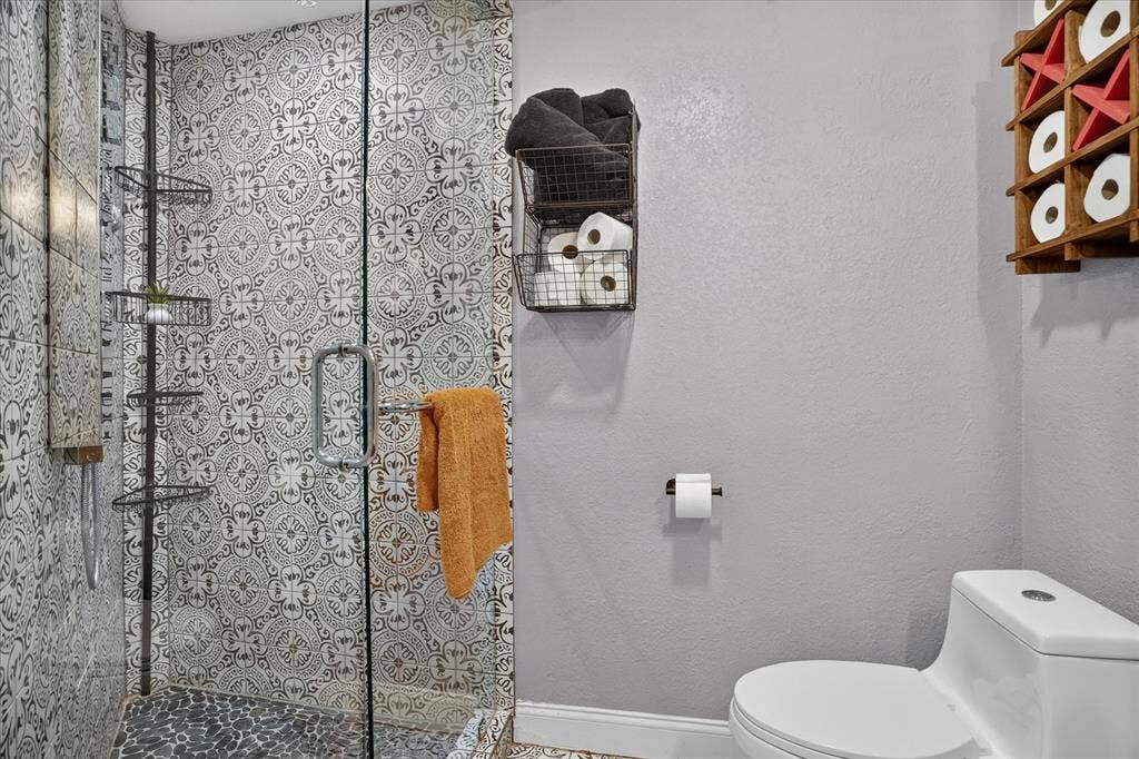 7016 Battle Creek Road, Fort Worth, TX 76116 Walk-in shower with patterned tile surround and clear glass enclosure